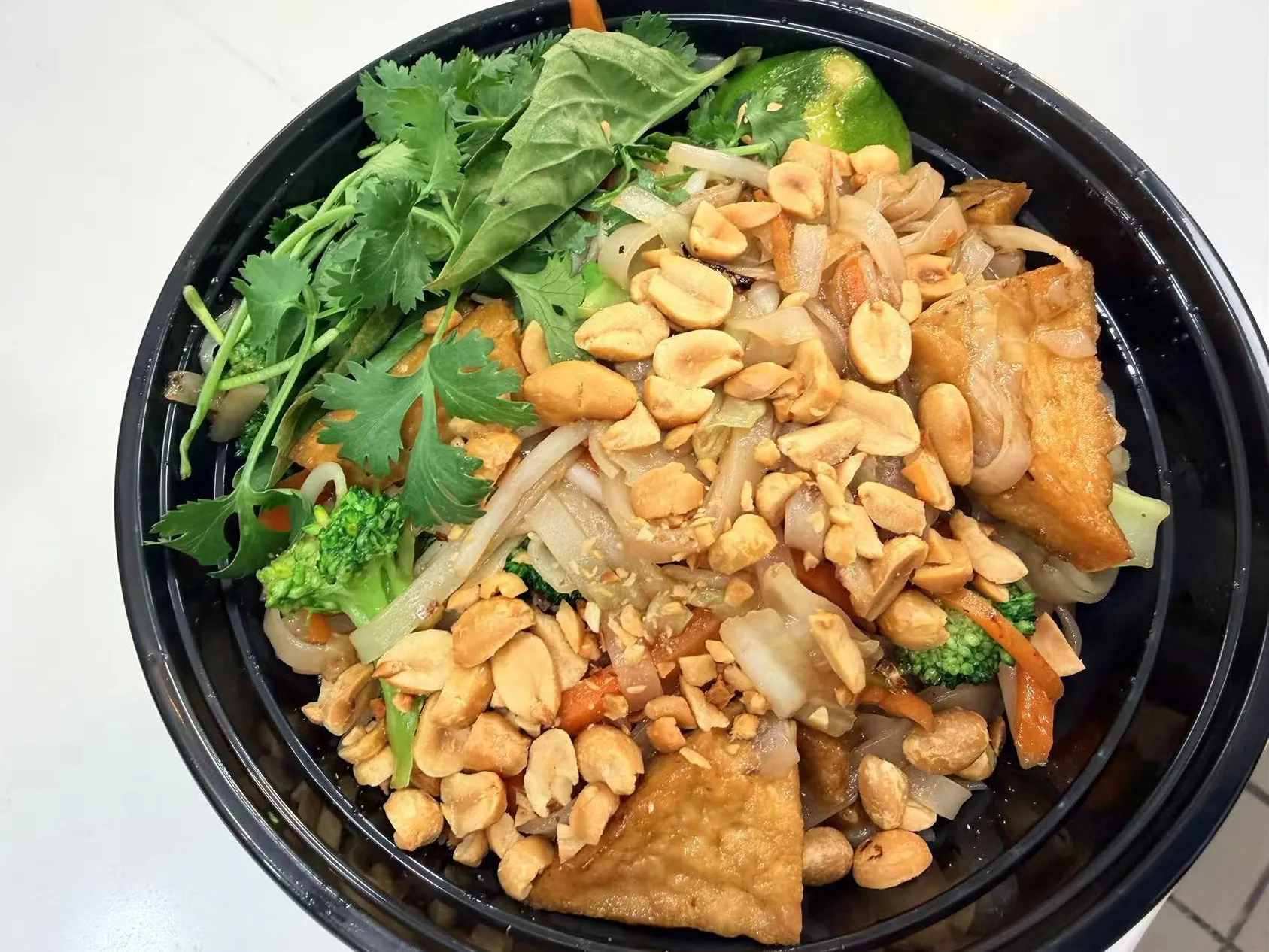 Vegan pad thai rice noodles topped with peanuts, tofu and fresh herb garnishes at Sam Bistro Thai Restaurant in Middletown