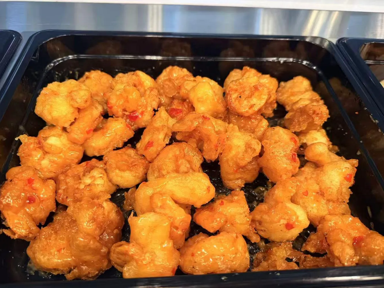 Crispy sweet chili fried shrimp coated in glossy spicy sauce in black tray at Sam Bistro Thai Restaurant in Middletown